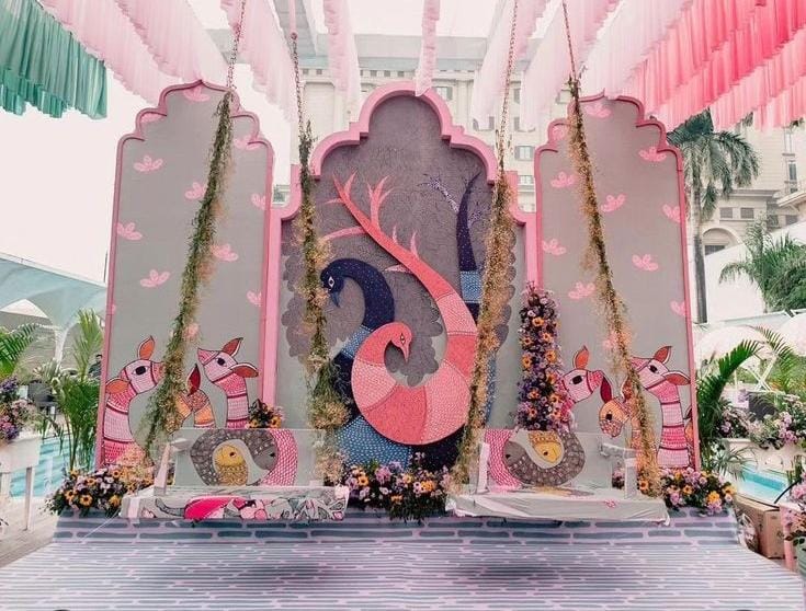 Pastel pink and teal poolside stage with a peacock motif and elephant cut-outs by RAW Group